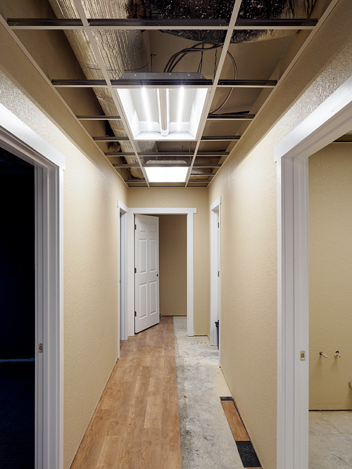 Air ductsabove the drop ceiling in the hallway of a new building under construction.