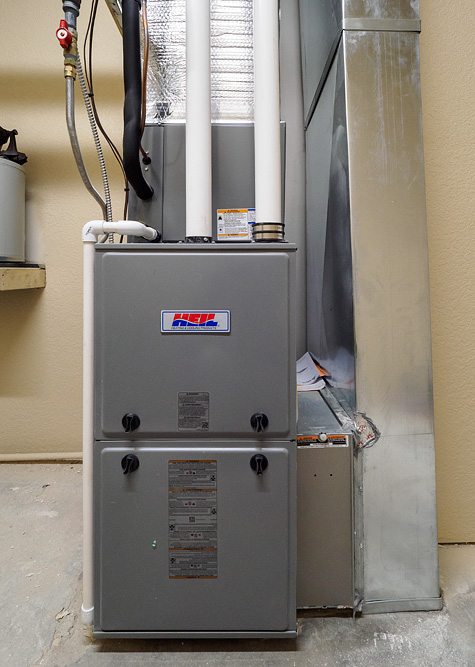 A gas furnace with the ducts, exhaust vents, and gaslines all hooked up.