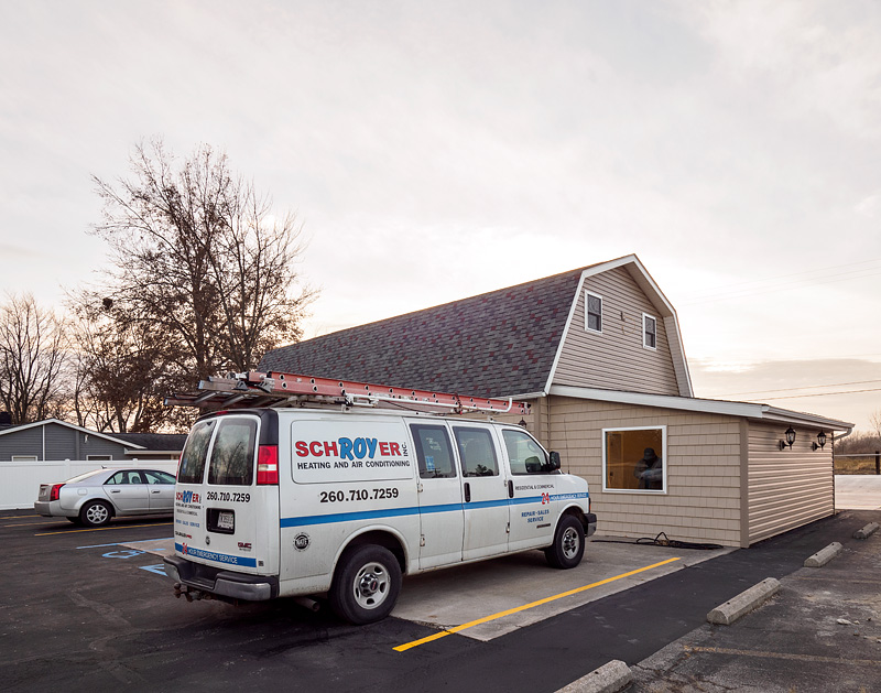 Schroyer Heating and Air Conditioning van parked in front of a building under construction.